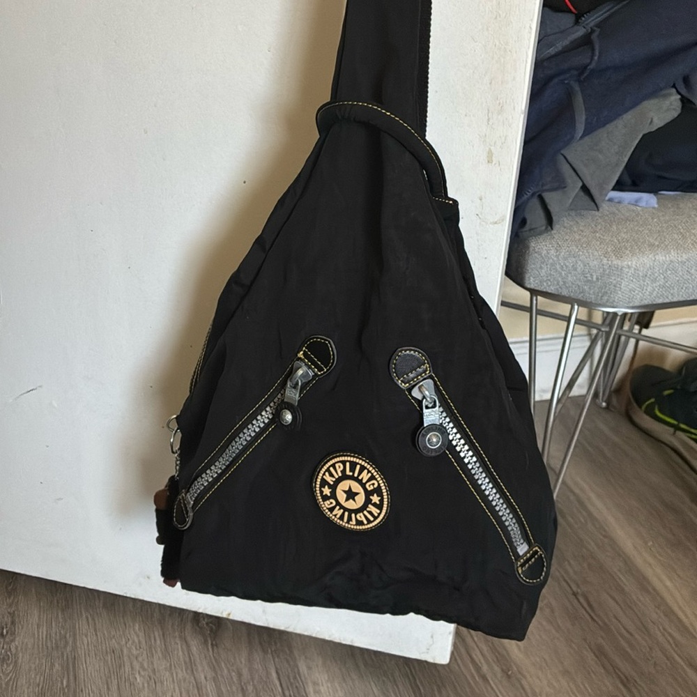 Kipling Black Triangle Sling Backpack with Gold Logo